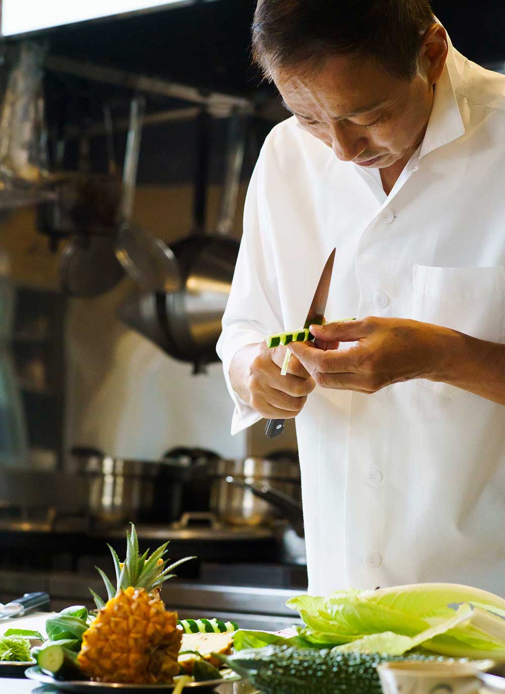 Mr. Nakamura cooks Yambaru vegetables at the pop-up kitchen 