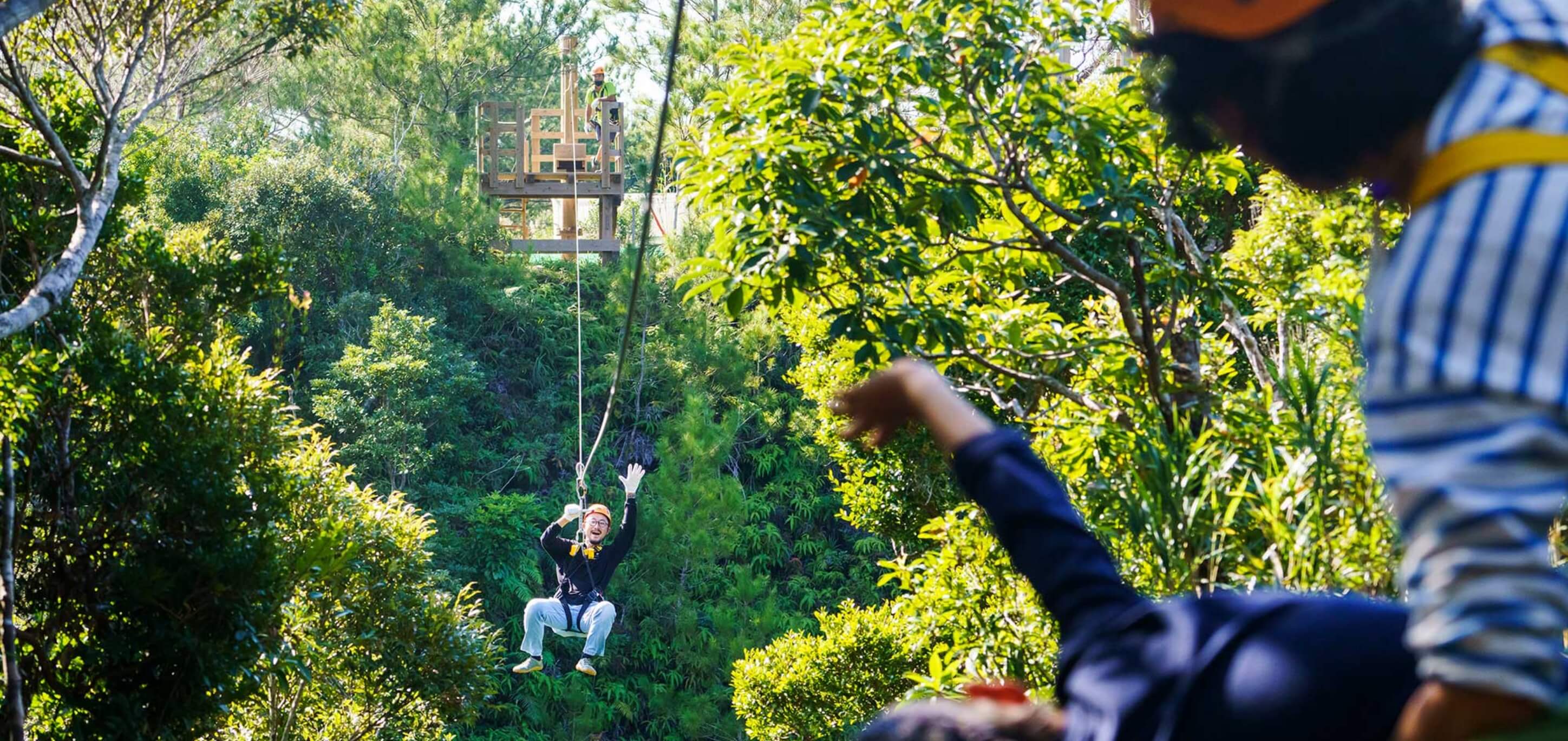 At first the Zipline makes you so afraid you can't move, but as you get used to it you are able to wave to your family with the Yambaru forest in the background.